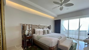 A spacious hotel room with a large bed, a sitting area, a ceiling fan, and a view of the outdoors. - Studio suite in Luxurious resort with scenic view in amazing Cabo San Lucas  (Cabo San Lucas)
