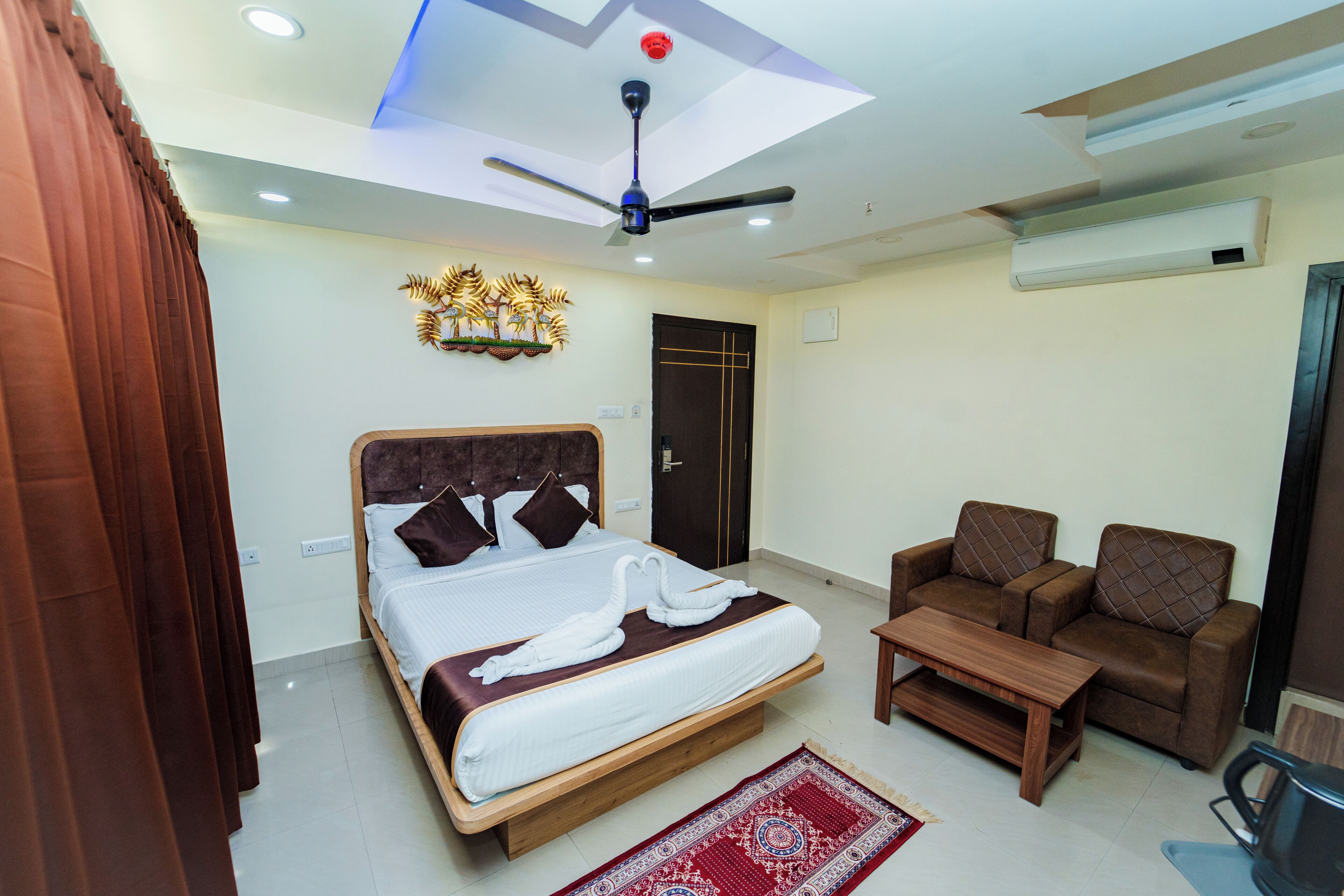 Une chambre d’hôtel équipée d’un lit, d’un canapé, d’une table basse, d’un ventilateur de plafond et d’un appareil de climatisation.