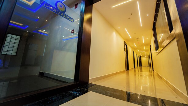 A hotel corridor with a glass wall, recessed lighting, and a polished floor. - Ravila Grand Hotel (Hyderabad)