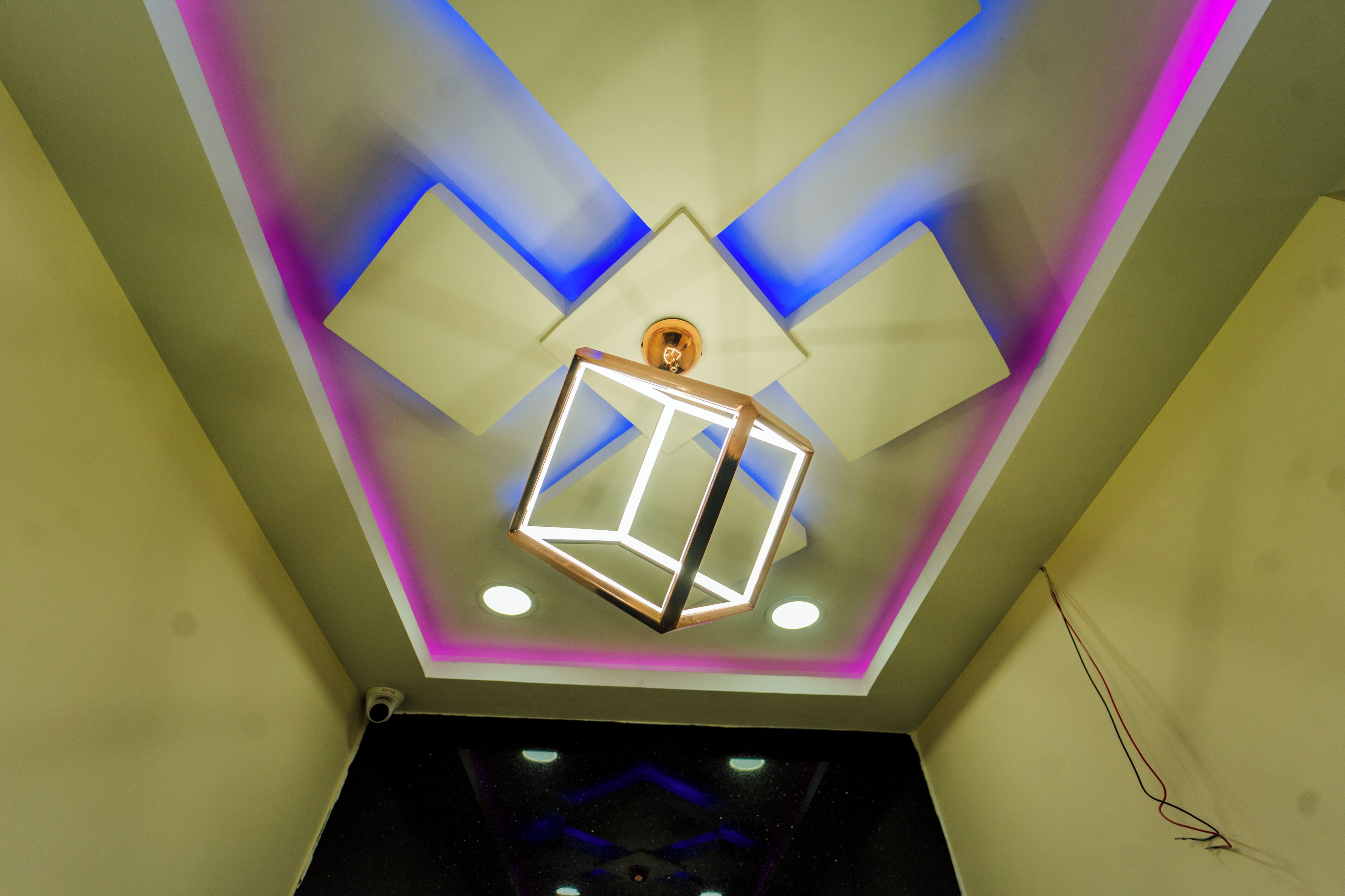 A ceiling with geometric patterns and recessed lighting.