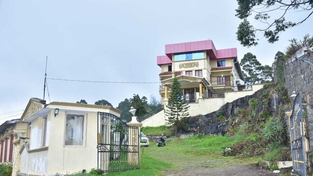A residential building with a red roof, a balcony, and a gated entrance. - RAJA STONE PALACE (Kodaikanal)