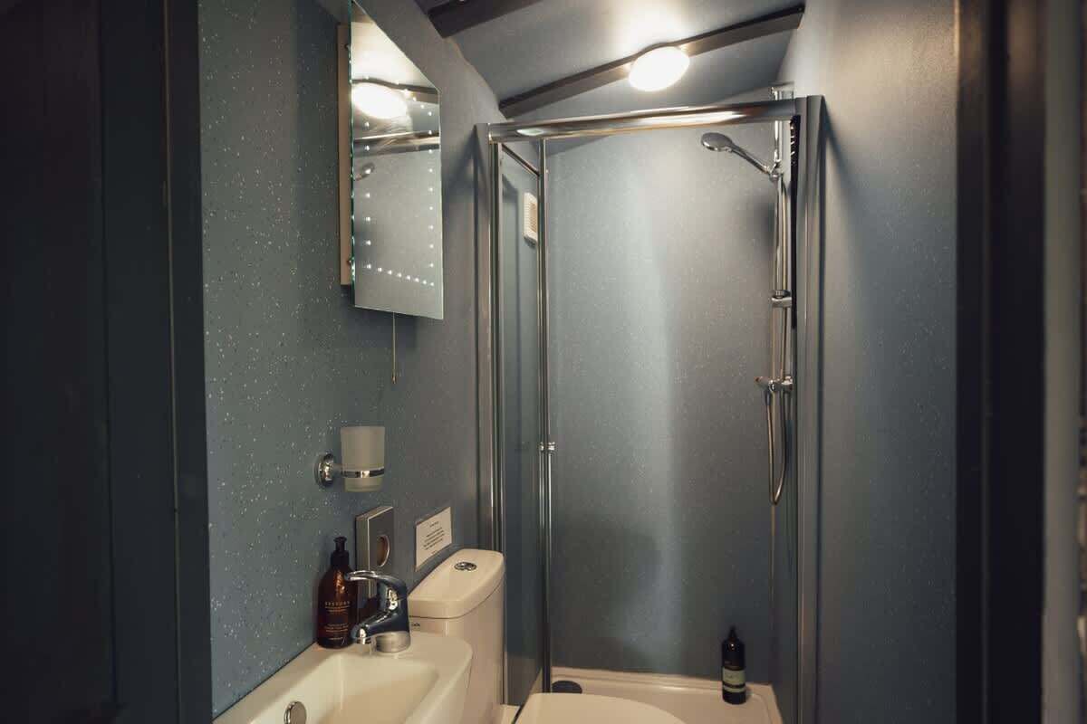 Un baño moderno con ducha acristalada, lavabo e inodoro.