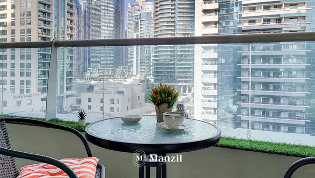 Ein Balkon mit Glastisch, Blumentopf und Dekorationselement.