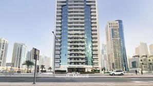Ein hohes, modernes Gebäude mit einer geschwungenen Fassade und mehreren Balkonen, mit einem Schild, das angibt, dass es sich um das Marina Diamond handelt.