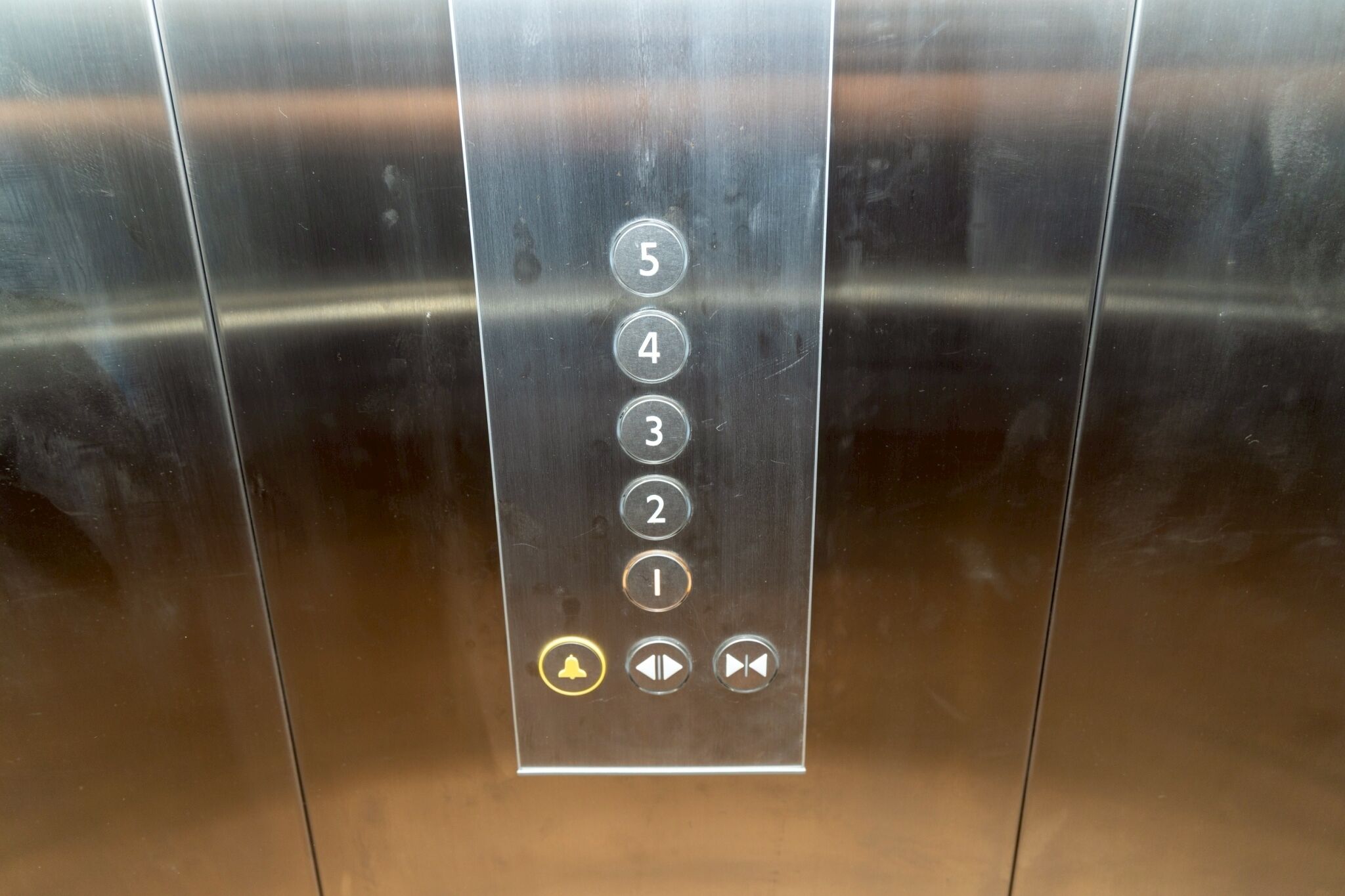 An elevator control panel with numbered buttons and a few symbols.