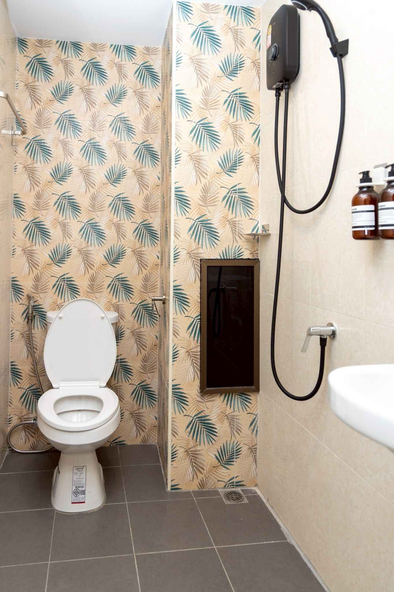A bathroom with a toilet, shower, and sink.