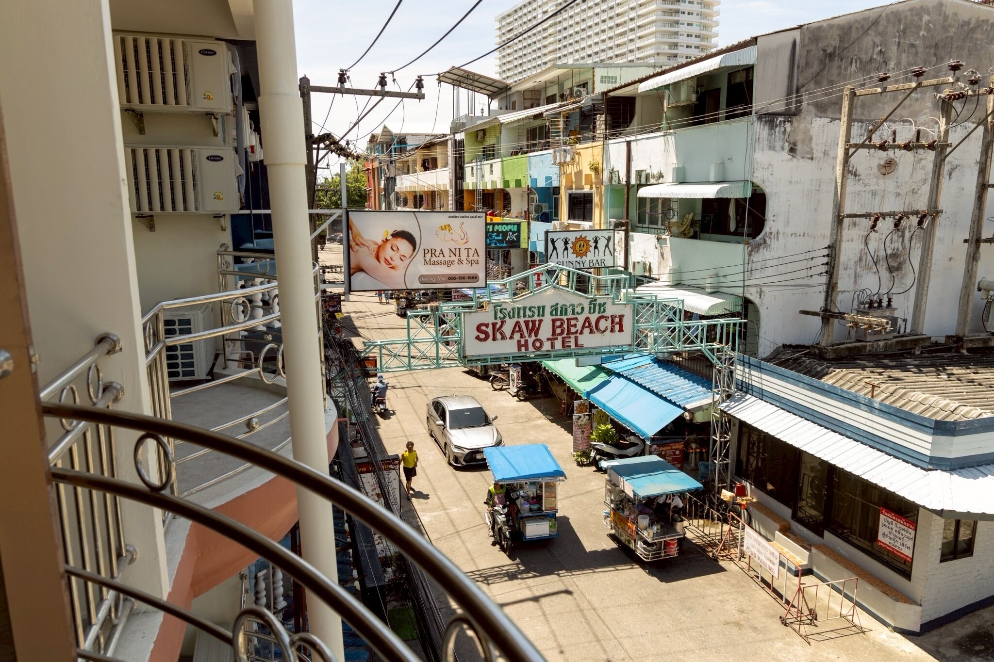 A multi-story building with a sign for "Skaw Beach Hotel" and a massage spa.