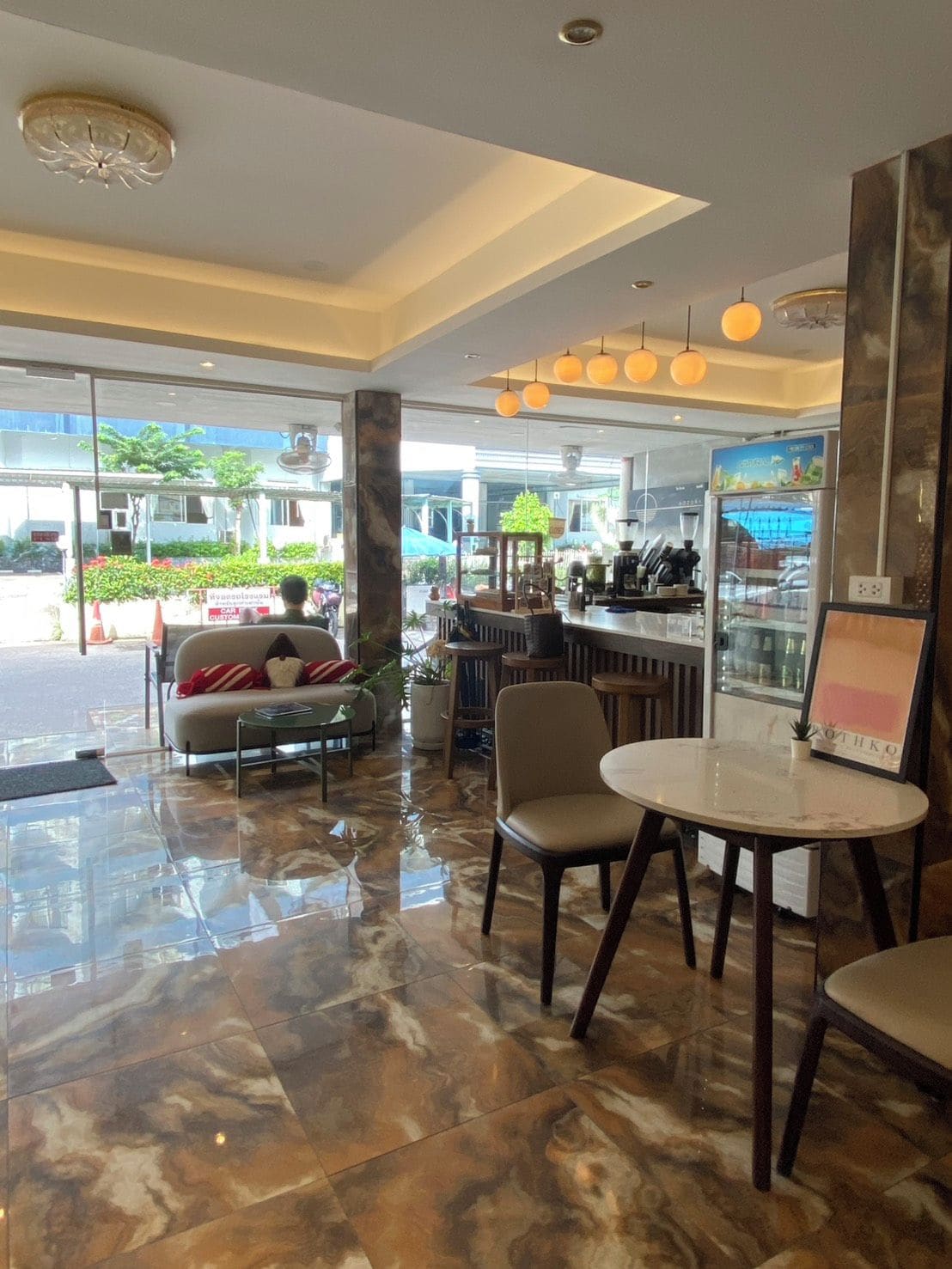 Un intérieur moderne avec un bar, des espaces pour s’asseoir et une vue sur l’extérieur.