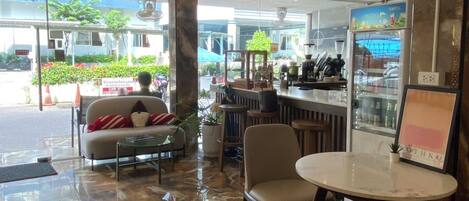 Un intérieur moderne avec un bar, des espaces pour s’asseoir et une vue sur l’extérieur.