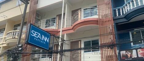 Un edificio de varios pisos con un letrero que dice 'SEA IN PATTAYA'.