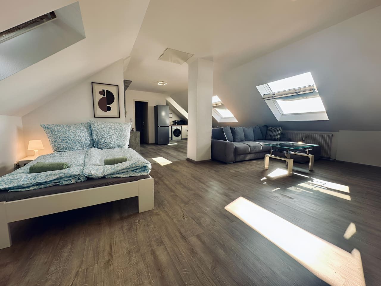 Een ruim loft appartement met een groot bed, een bank en een eethoek.