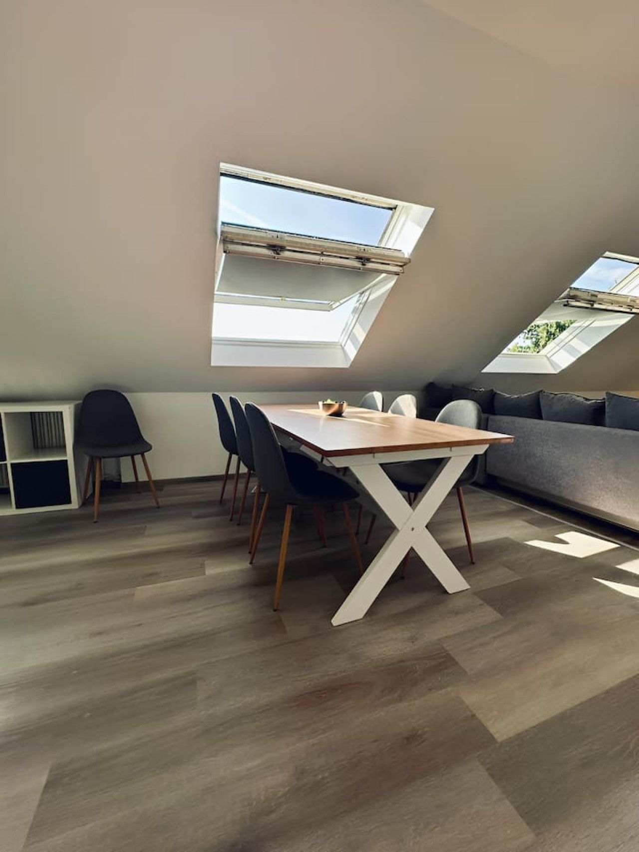 Een moderne loft slaapkamer met dakraam, een eethoek en een bank.