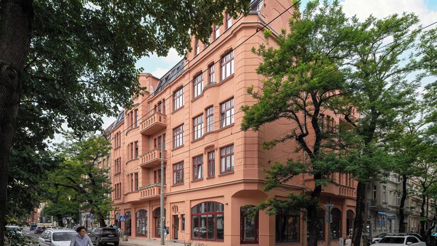 Un immeuble à plusieurs étages, de style architectural classique, doté de grandes fenêtres et de balcons.