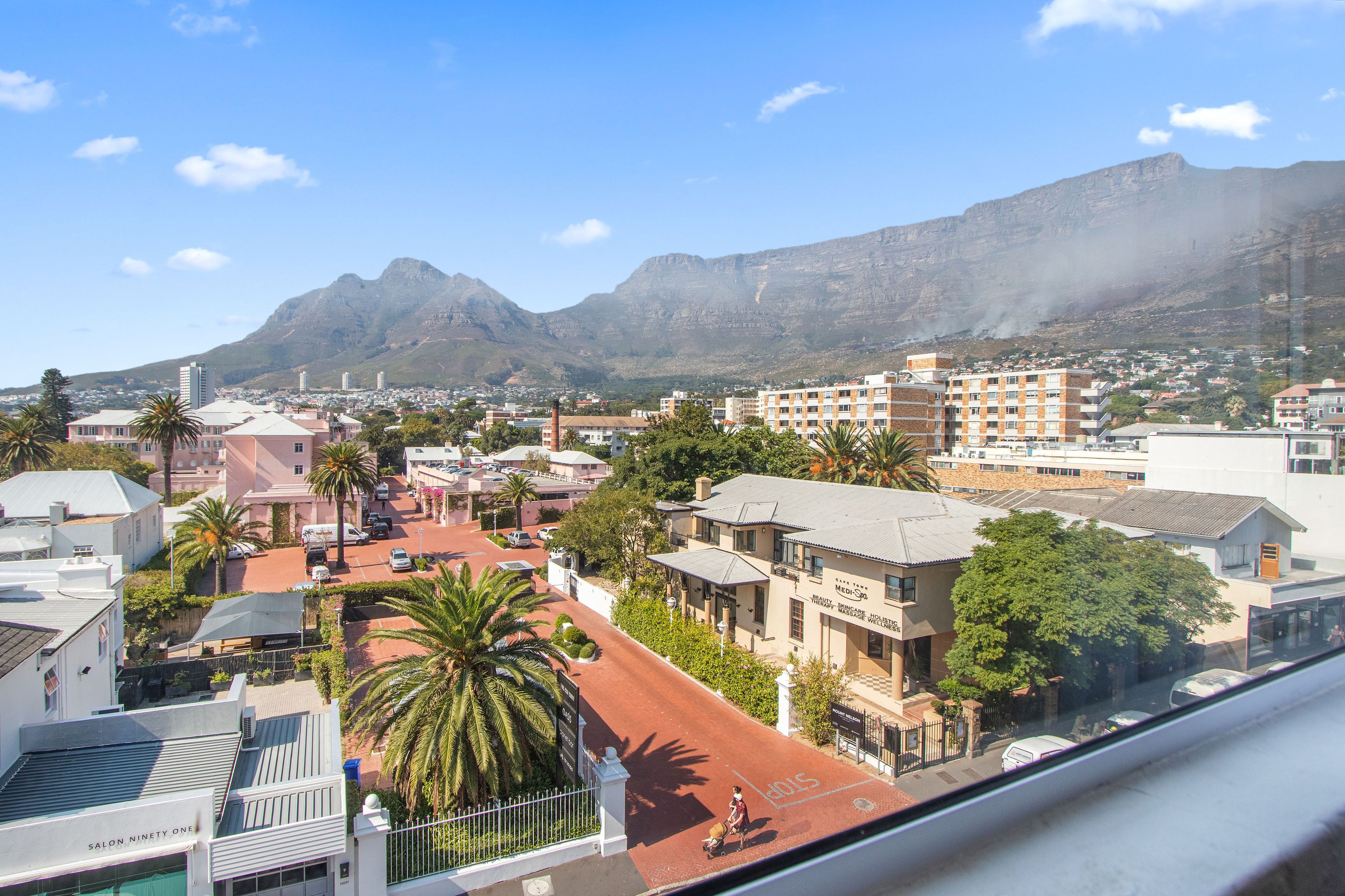 A cityscape with buildings, a street, and a mountain in the background.
