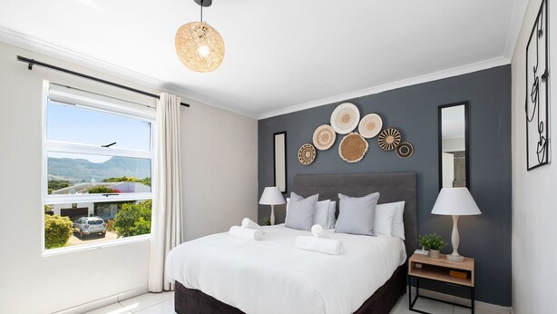 Un dormitorio moderno con una cama grande, lámparas de noche y decoración mural.