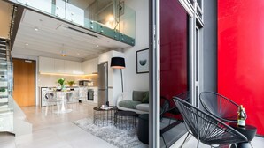 Um apartamento moderno com cozinha, sala de jantar e varanda com cadeiras.