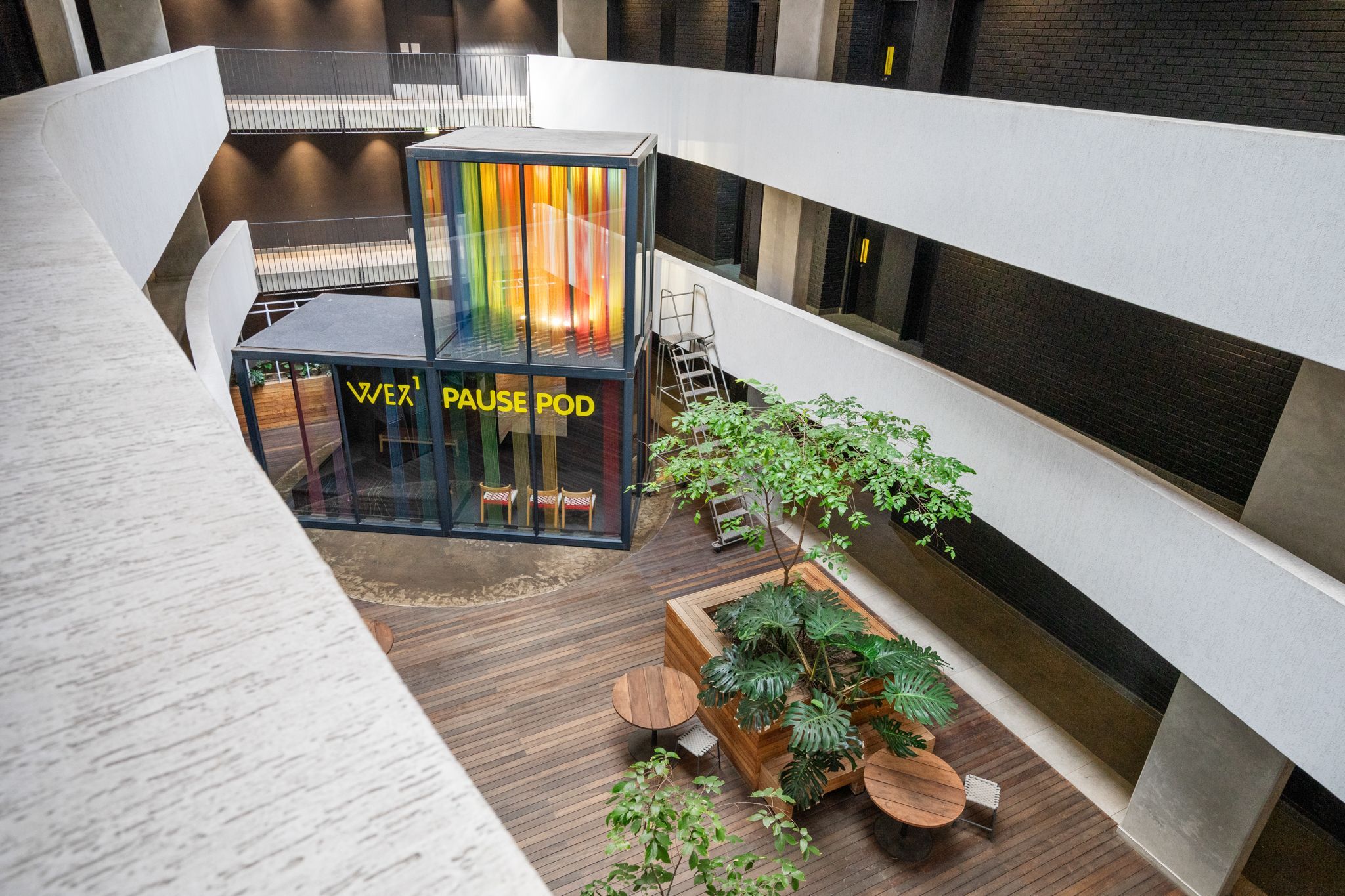 Un intérieur moderne avec un espace clos en verre portant l’inscription « ESPACE DÉTENTE » et un revêtement de sol en bois.