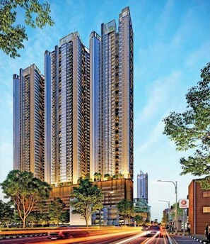A high-rise residential building with multiple balconies, surrounded by trees and a busy street. - YAKA Trizen Luxury Apartments (Colombo)