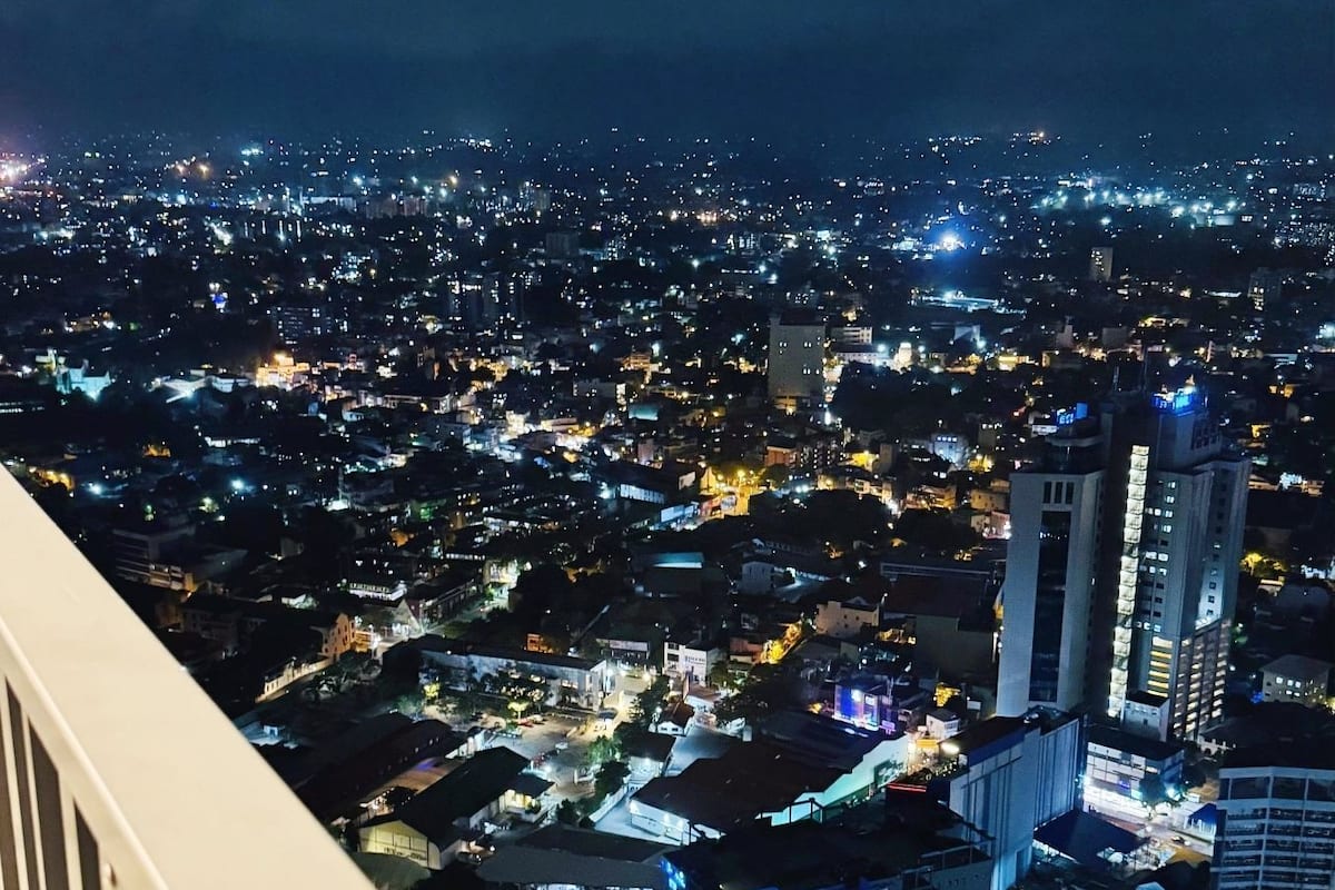 A nighttime cityscape viewed from a balcony.