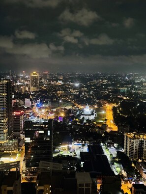 A nighttime cityscape with illuminated buildings and streets. - YAKA Trizen Luxury Apartments (Colombo)