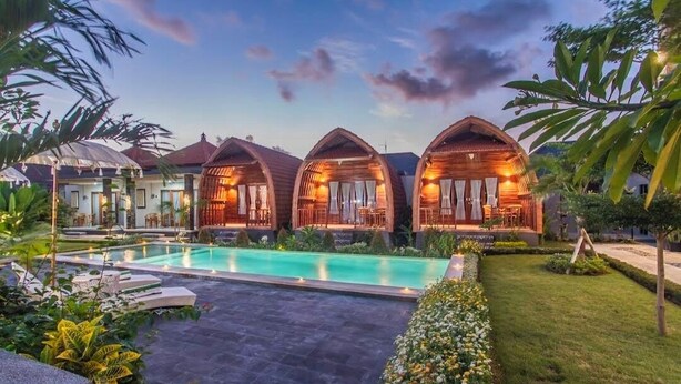 A resort with wooden cabins, a swimming pool, and lush greenery. - MAILAKU HOUSE (Kerobokan Kaja)