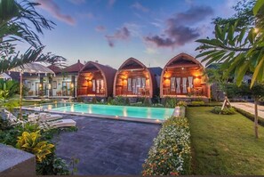 A resort with wooden cabins, a swimming pool, and lush greenery. - MAILAKU HOUSE (Kerobokan Kaja)