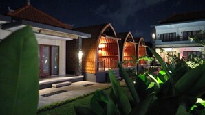A traditional house with a tiled roof, a wooden porch, and a well-lit interior. - MAILAKU HOUSE (Kerobokan Kaja)