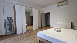 A bedroom with a bed, a wardrobe, a mirror, and a radiator. - Centrally located in Sliema, this apartment puts you steps from shops, restaurants, cafés, and the lively promenade (Tas-Sliema)