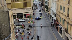 A street view with buildings, a construction crane, and a 'next' store with a sale sign. - Centrally located in Sliema, this apartment puts you steps from shops, restaurants, cafés, and the lively promenade (Tas-Sliema)