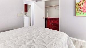 A bedroom with a white bedspread, a wooden dresser, and a white wardrobe. - Private Yard w/ Pool: Quiet Getaway in San Antonio (San Antonio)