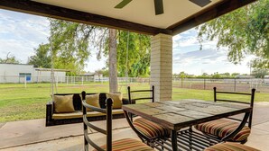 An outdoor patio area with a table and chairs, a swing, and a view of a sports field. - Family Home on > 2 Acres w/ Stables in Gilbert! (Gilbert)