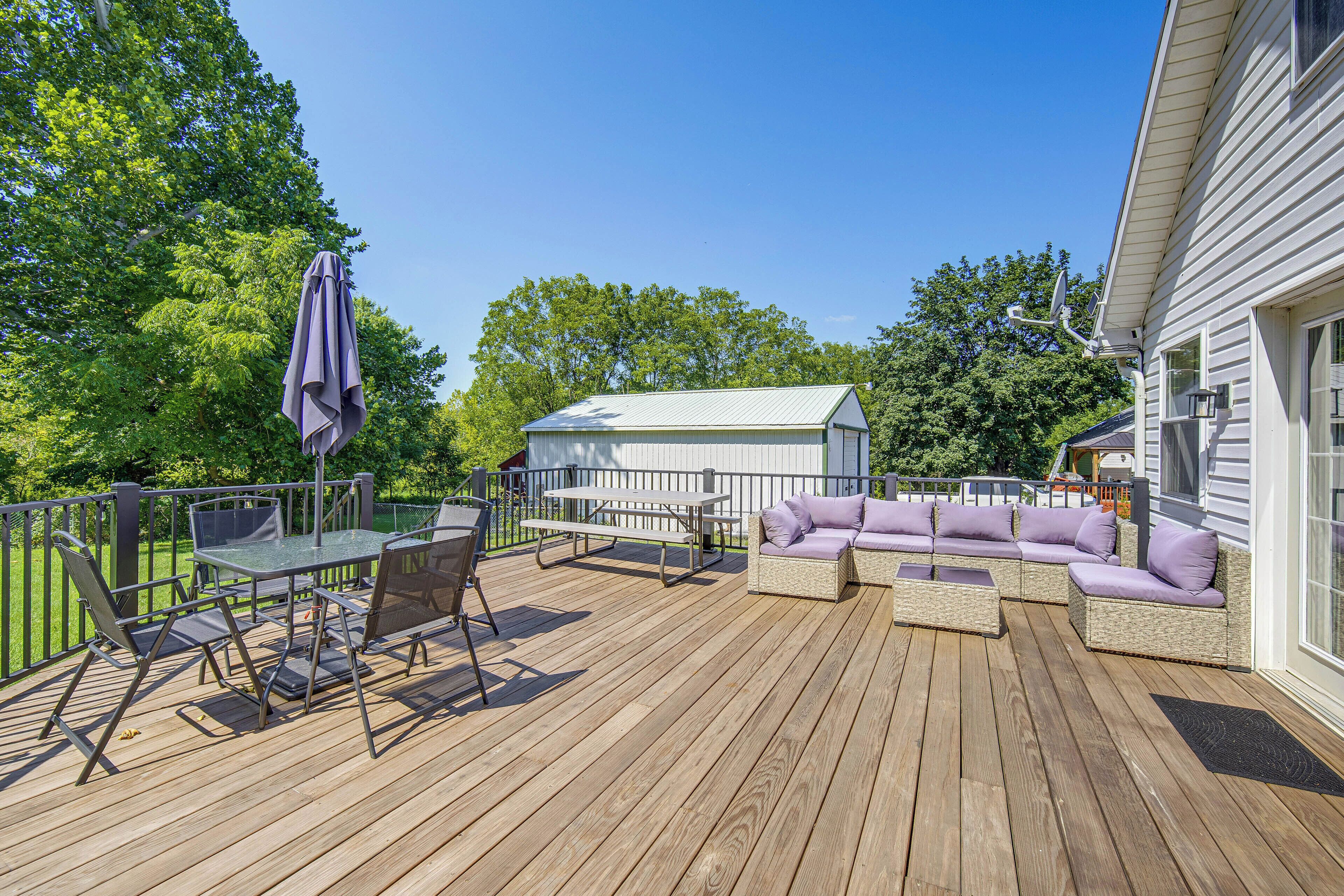 Eine Holzterrasse mit Gartenmöbeln, darunter ein Tisch, Stühle und eine Sitzecke.