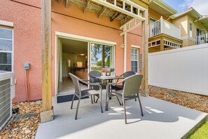 A patio with a table and chairs, a wooden fence, and a building with a balcony. - Townhouse in Lake Berkley Resort! 5 Mi to Old Town (Kissimmee)