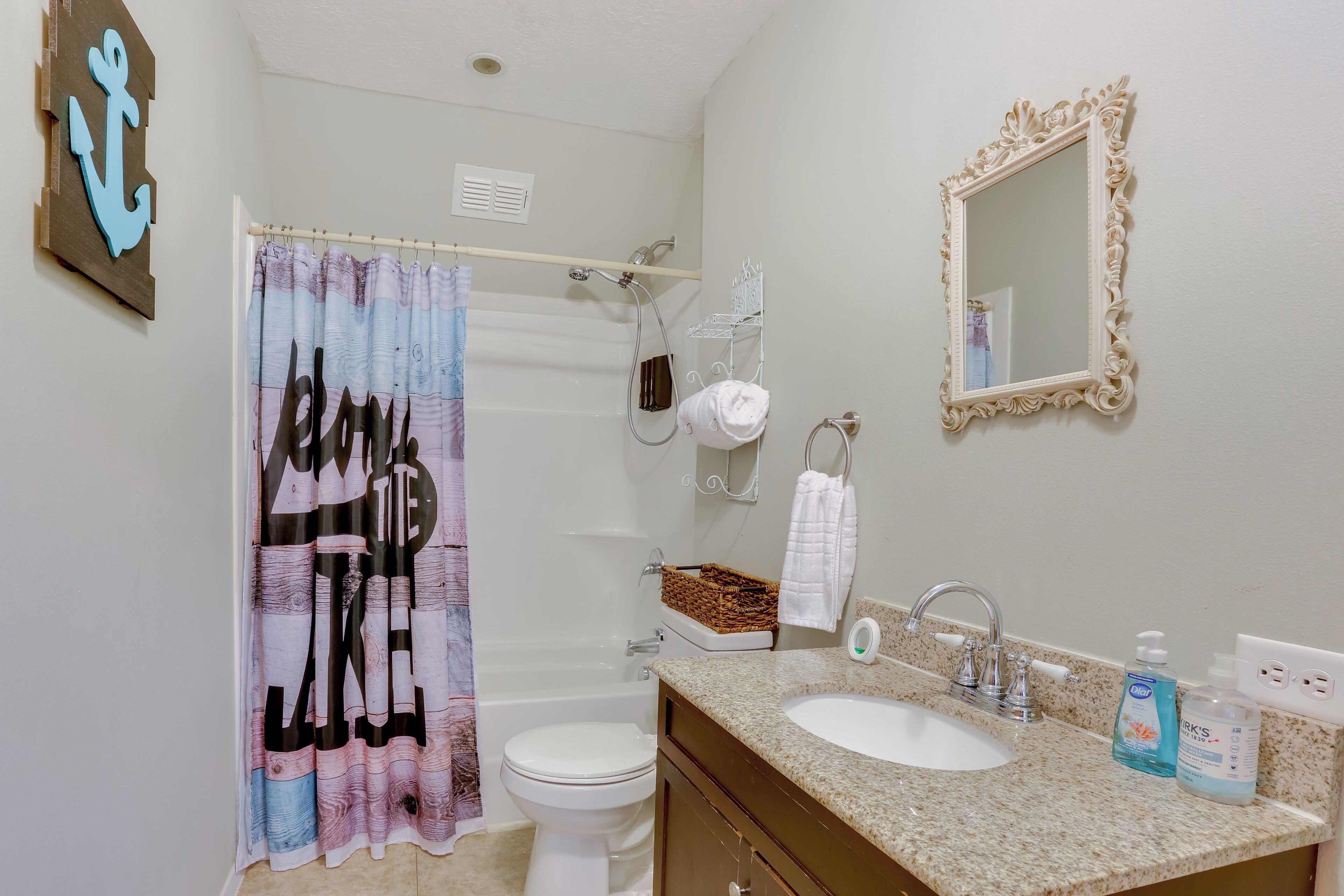 Une salle de bain équipée d’une douche, de toilettes, d’un lavabo et d’un miroir.