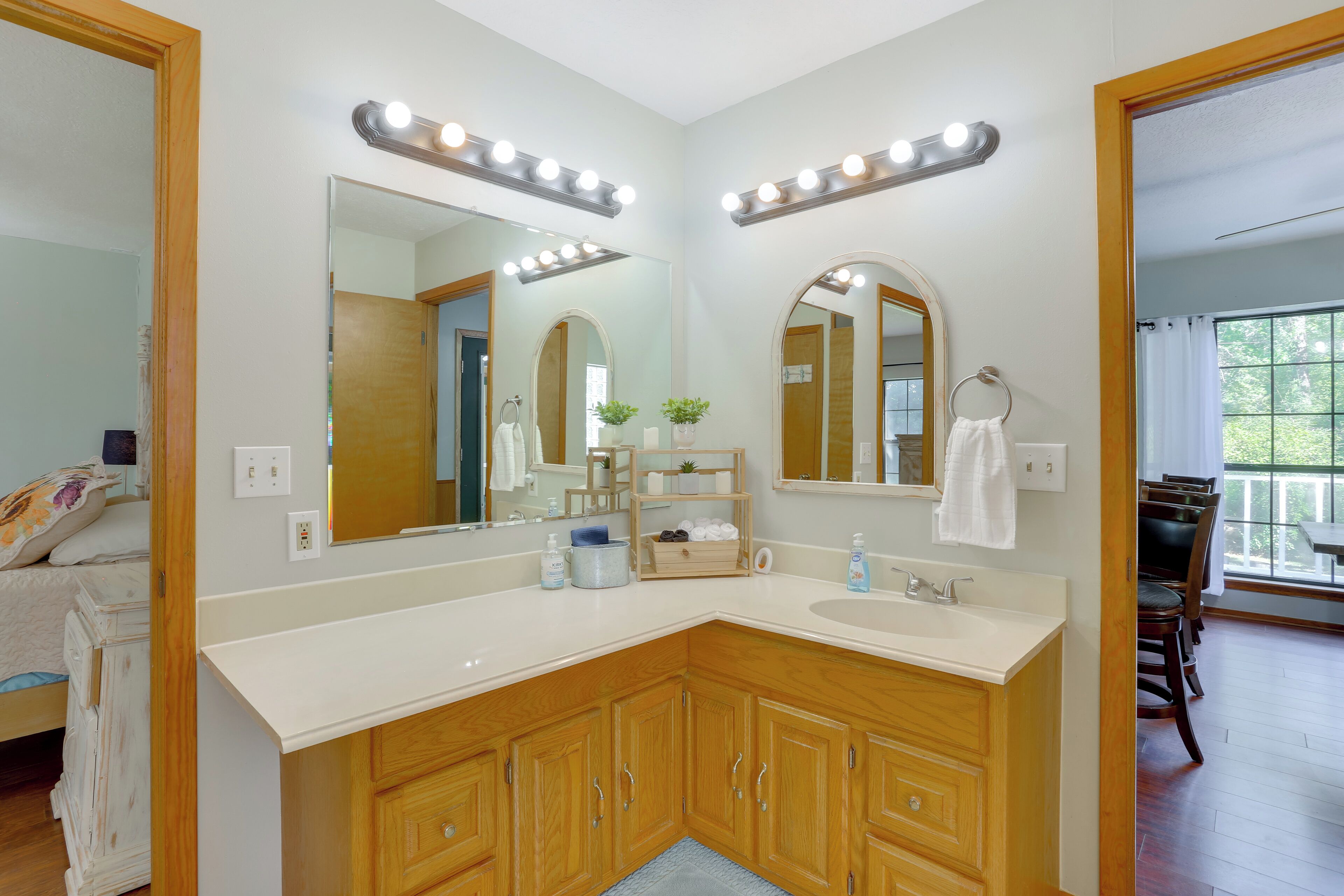 Une salle de bain avec un meuble-lavabo, deux miroirs au-dessus du meuble-lavabo et un évier.