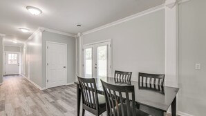 A dining area with a dark wooden table and chairs, light grey walls, and a herringbone-patterned floor. - 11 Mi to Fort Lee: 5-acre Retreat w/ Scenic Views (Petersburg)