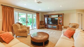A living room with a large TV, two sofas, a coffee table, and a fireplace. - Golf Getaway 5 Mi to Dtwn: Las Palmas Resort Condo (St. George)