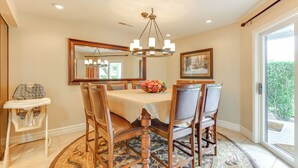 A dining room with a round table, chairs, a chandelier, a mirror, and a view through a glass door. - Golf Getaway 5 Mi to Dtwn: Las Palmas Resort Condo (St. George)