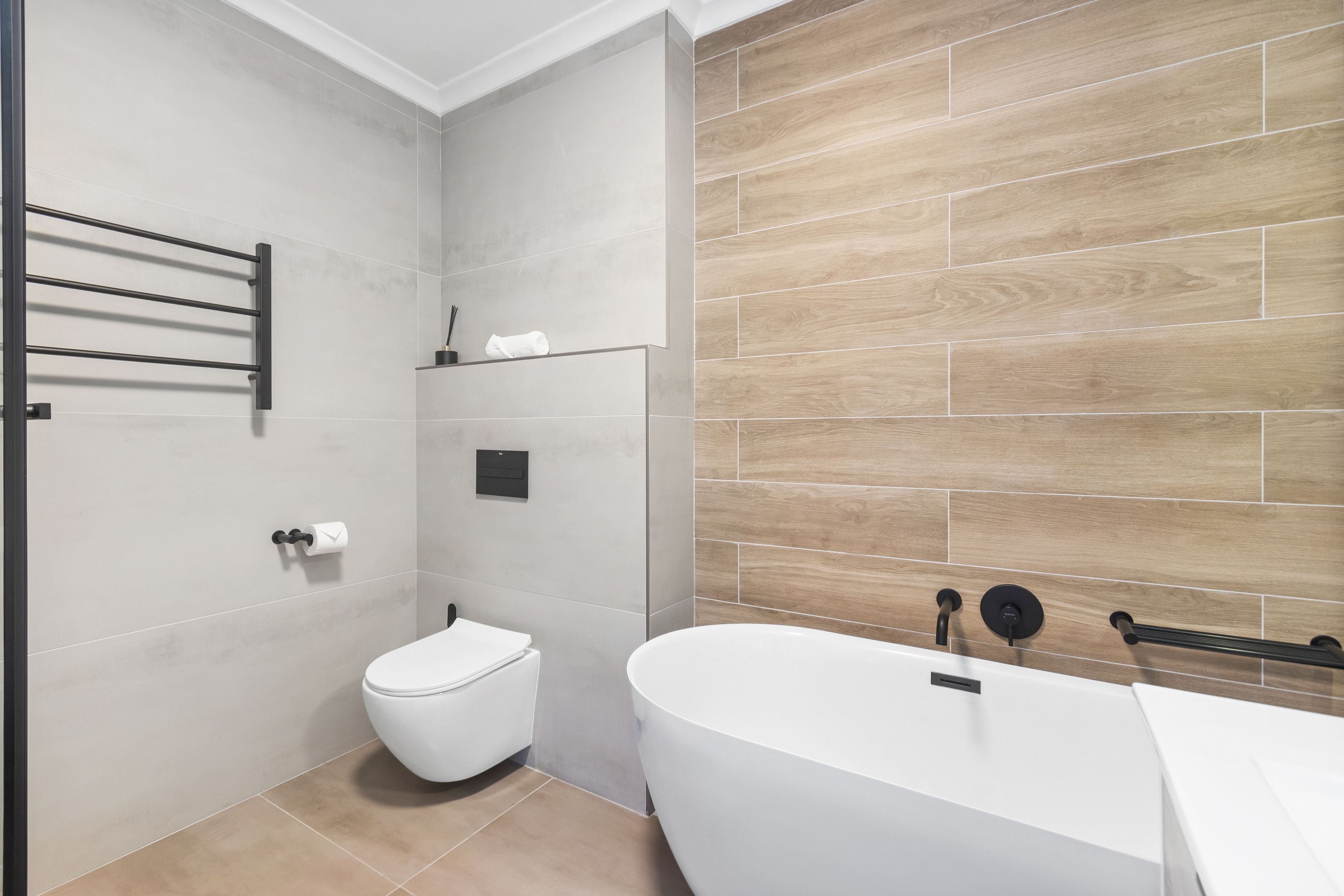 Ein modernes Badezimmer mit Toilette, einer Badewanne und einem Handtuchhalter.