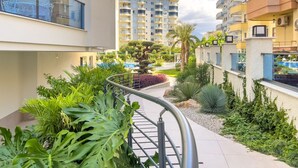 Zona residencial con edificios de apartamentos modernos, una piscina y jardines ajardinados.