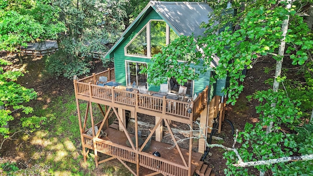 A wooden deck with outdoor seating and a view of the surrounding forest. - Above It All Cabin - Mountain Views (Murphy)