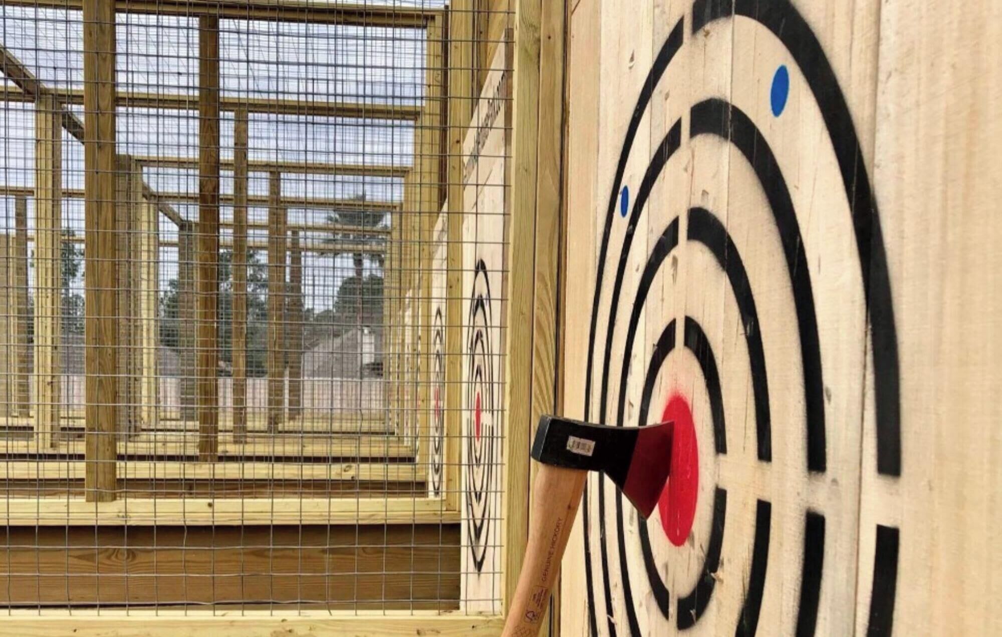 Un tablero de dardos con el centro rojo y una flecha en él.