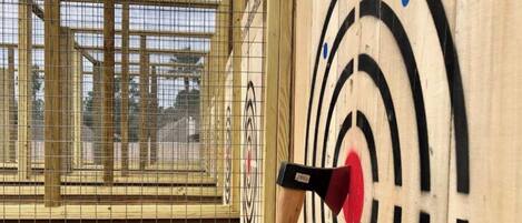 Un tablero de dardos con el centro rojo y una flecha en él.