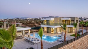 A modern two-story house with a swimming pool, outdoor seating, and a view of the surrounding landscape. - Divel Luxury Villas - Villa Ervin by Estia (Hersonissos)