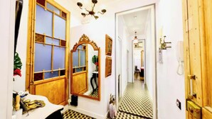 A bathroom with a wooden vanity, a mirror, and a patterned floor.