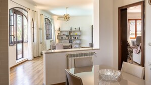 A modern kitchen with a dining area, a large window, and a view of the outdoors.