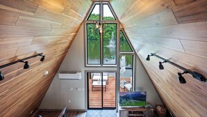 Un intérieur moderne avec des lambris en bois, de grandes fenêtres et une vue sur un lac.