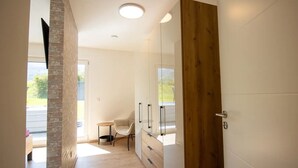 A modern room with a wooden door, a small table, and a chair.