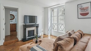 Una sala de estar moderna con chimenea, televisor y un ventanal grande.