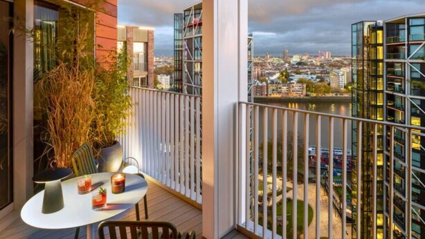 A balcony with a table, chairs, and a view of a cityscape and river. - 2bed-2bath-2balconylondoneyeview (London)